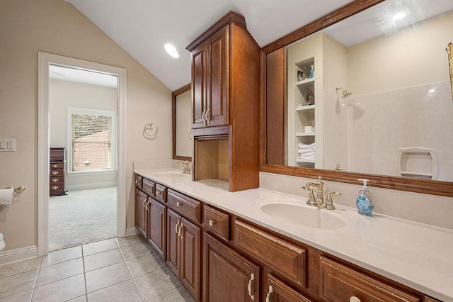 bathroom featuring tile patterned floors, vaulted ceiling, and vanity