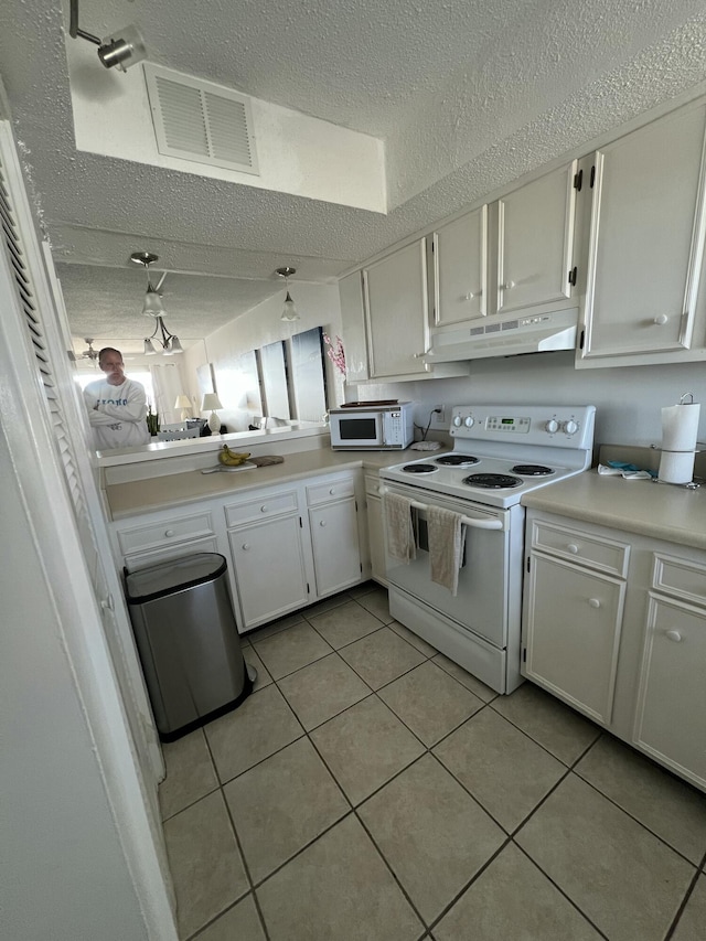 kitchen with visible vents, under cabinet range hood, white appliances, white cabinets, and light countertops