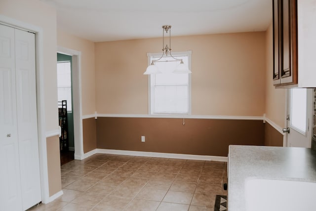 unfurnished dining area featuring light tile patterned floors