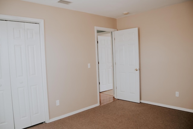 unfurnished bedroom with carpet floors and a closet