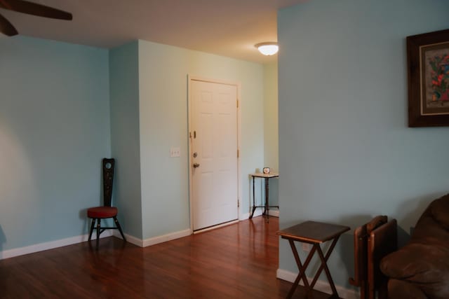 living area featuring dark wood-type flooring and ceiling fan