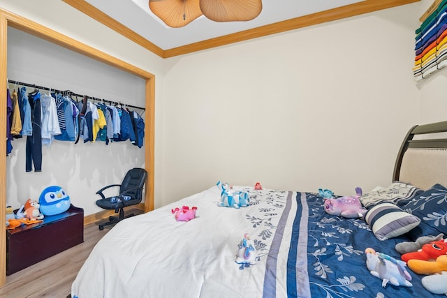 bedroom with crown molding, wood-type flooring, a closet, and ceiling fan