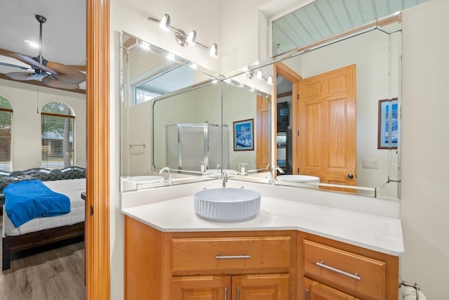 bathroom featuring hardwood / wood-style flooring, ceiling fan, vanity, and a shower with door