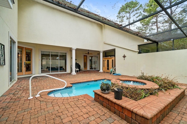 view of swimming pool featuring a hot tub, a patio, a lanai, and ceiling fan