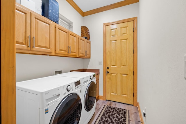 laundry room featuring cabinets, ornamental molding, washing machine and dryer, and light hardwood / wood-style floors