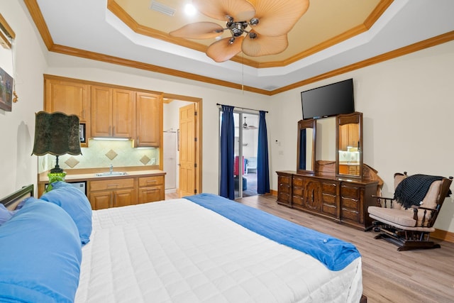 bedroom featuring ornamental molding, a raised ceiling, sink, and light hardwood / wood-style flooring