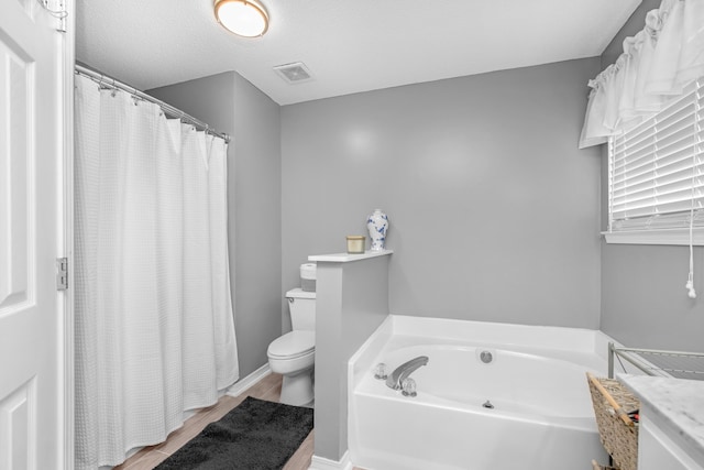 1775 Village Pkwy, Gulf Breeze, FL 32563 - bathroom with a washtub, a textured ceiling, and toilet
