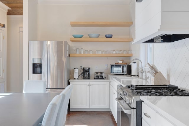 kitchen with sink, range hood, stainless steel appliances, white cabinets, and decorative backsplash