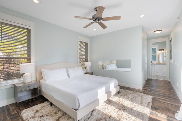 bedroom with multiple windows, dark hardwood / wood-style floors, and ceiling fan