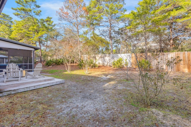 view of yard featuring a wooden deck and a sunroom