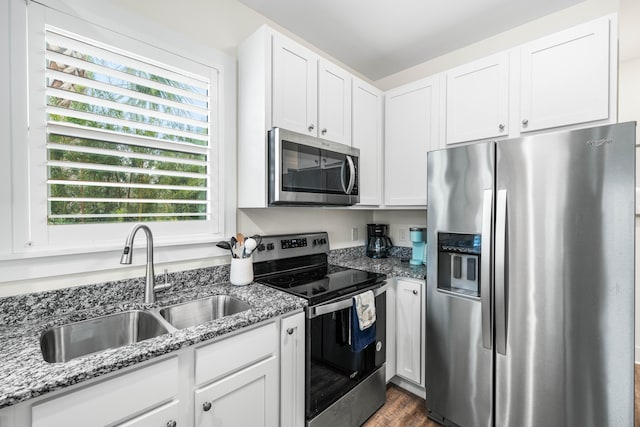 kitchen with sink, white cabinets, stainless steel appliances, light stone countertops, and dark wood-type flooring