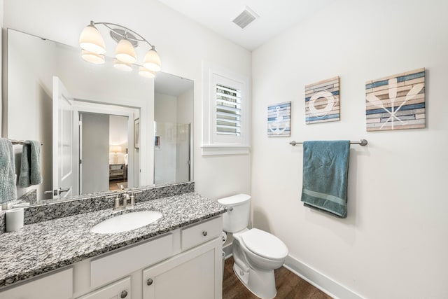 bathroom with hardwood / wood-style flooring, vanity, walk in shower, and toilet