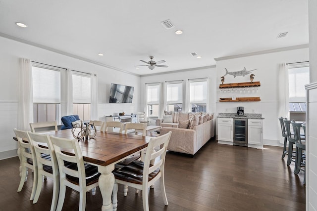 dining room featuring wine cooler, crown molding, dark hardwood / wood-style flooring, and a healthy amount of sunlight