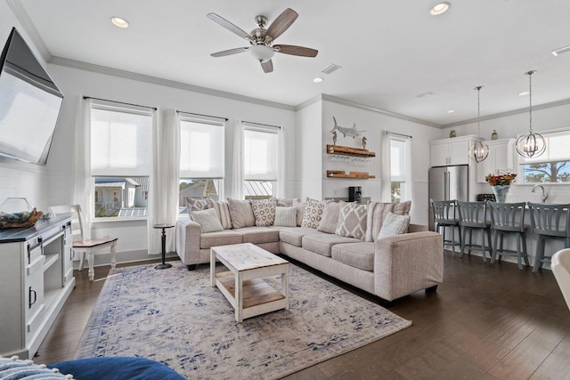 living room featuring crown molding, a wealth of natural light, and dark hardwood / wood-style flooring