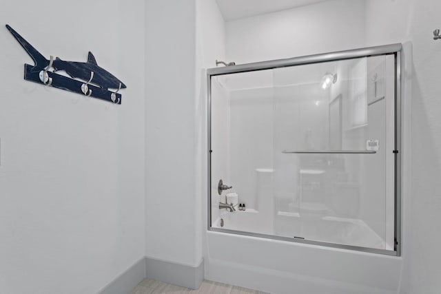 bathroom featuring shower / bath combination with glass door