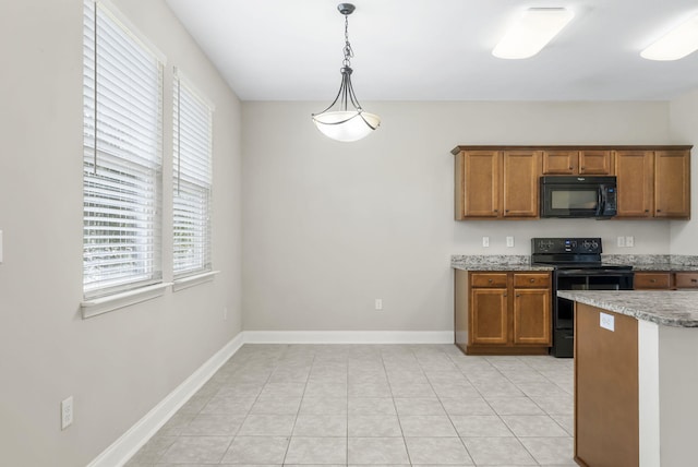 kitchen with hanging light fixtures, light tile patterned floors, and black appliances