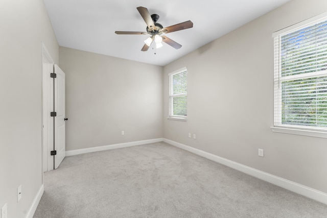 spare room with plenty of natural light, light carpet, and ceiling fan