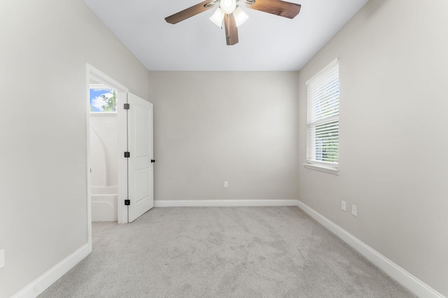 unfurnished room featuring ceiling fan and light carpet