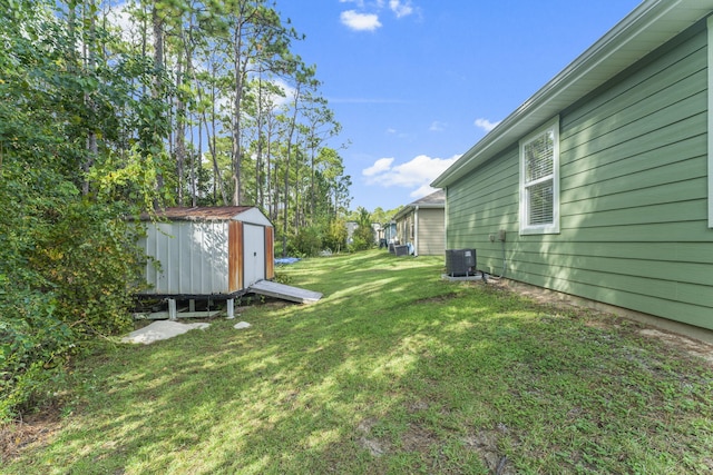 view of yard featuring central AC and a storage unit