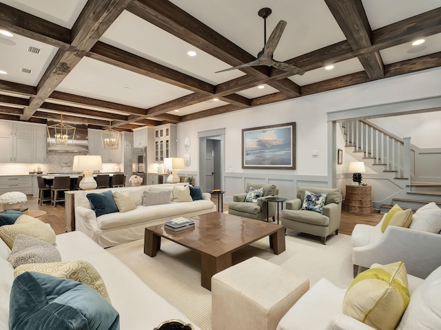 living room with coffered ceiling, beam ceiling, and a chandelier