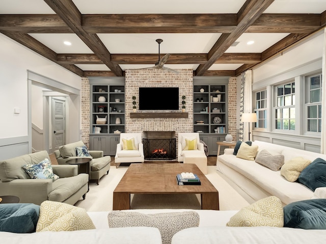 living room featuring built in shelves, coffered ceiling, a brick fireplace, and beamed ceiling