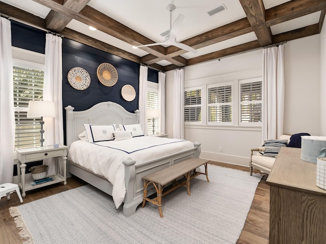 bedroom featuring coffered ceiling, beam ceiling, and wood-type flooring