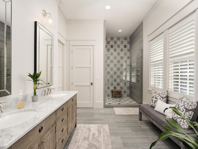 bathroom featuring vanity, ornamental molding, and a tile shower