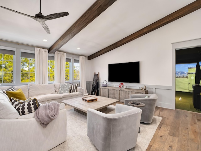 living room featuring vaulted ceiling with beams, ceiling fan, and light wood-type flooring