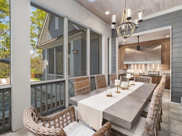 dining space featuring wood ceiling, a healthy amount of sunlight, wooden walls, and ceiling fan with notable chandelier