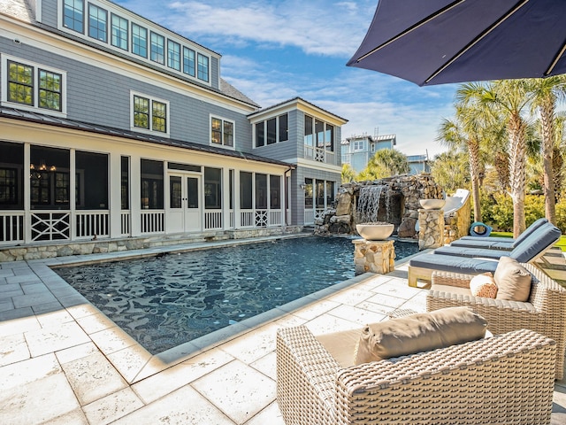 view of pool featuring a patio area and a sunroom