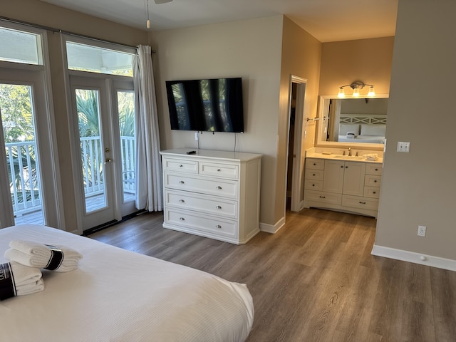 bedroom with sink, hardwood / wood-style flooring, access to outside, and ensuite bathroom