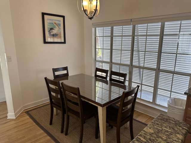 dining space with a wealth of natural light, a notable chandelier, and light hardwood / wood-style floors