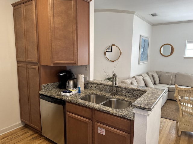 kitchen with dark stone countertops, sink, kitchen peninsula, and dishwasher