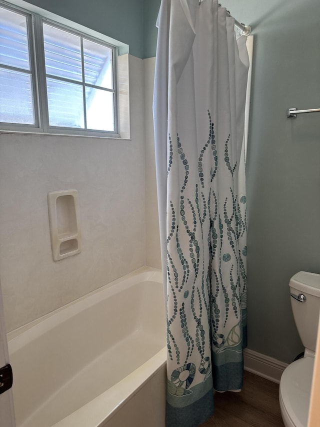 bathroom with shower / tub combo, hardwood / wood-style flooring, and toilet