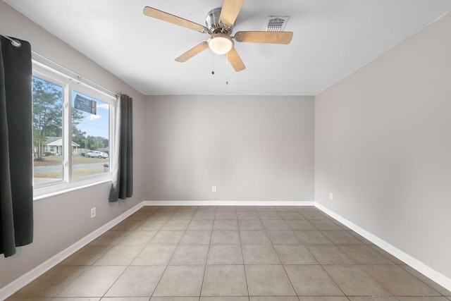 tiled empty room featuring ceiling fan