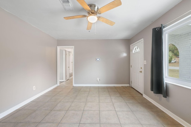 tiled spare room featuring ceiling fan