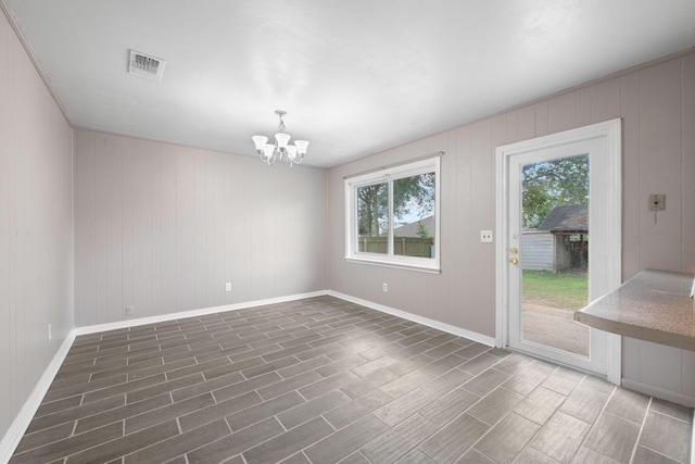 spare room featuring dark hardwood / wood-style floors and a chandelier