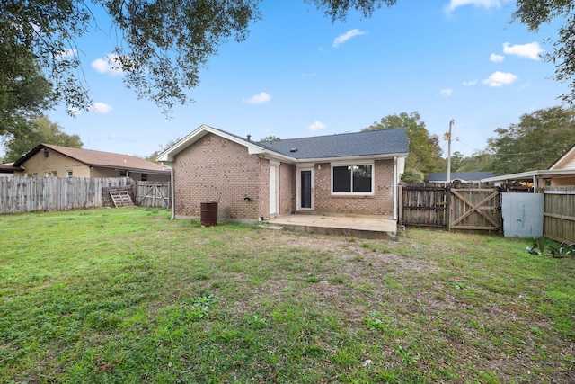 rear view of property featuring a patio area and a lawn