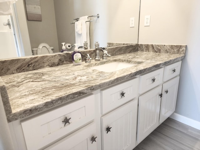 bathroom featuring vanity, toilet, and hardwood / wood-style floors