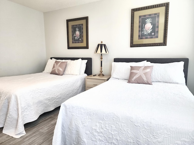 bedroom featuring hardwood / wood-style flooring and a textured ceiling