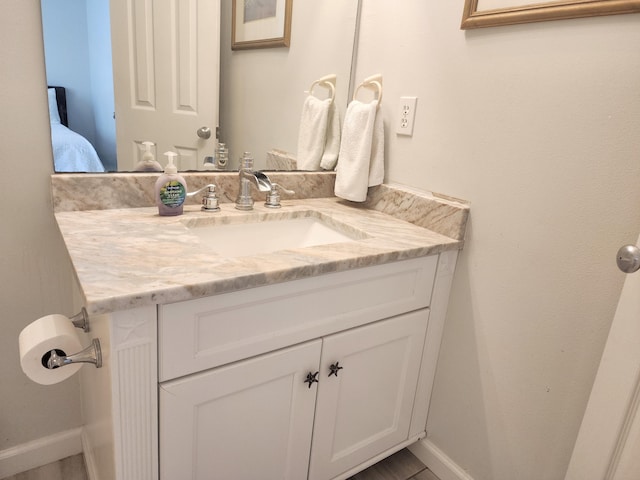 ensuite bathroom featuring baseboards, ensuite bathroom, and vanity