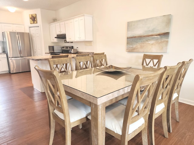 dining space with dark wood finished floors and baseboards