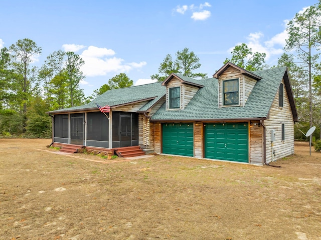 view of front of home with a garage, a front lawn, and a sunroom