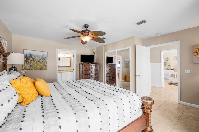 bedroom featuring visible vents, a ceiling fan, light tile patterned flooring, connected bathroom, and baseboards