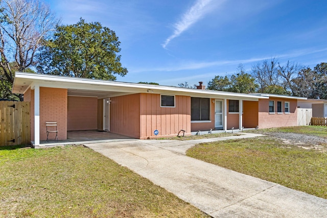 ranch-style house with a front yard and a carport