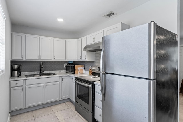 kitchen featuring light tile patterned flooring, sink, tasteful backsplash, stainless steel appliances, and white cabinets