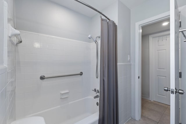 bathroom featuring shower / tub combo, tile patterned flooring, and tile walls