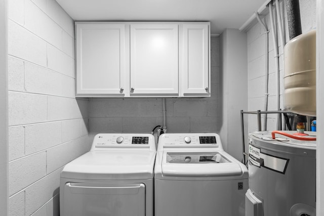 washroom with water heater, washer and clothes dryer, and cabinets