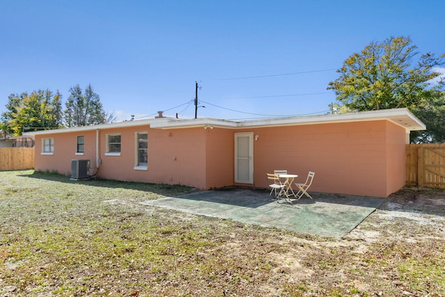 rear view of house with a yard, a patio area, and central air condition unit