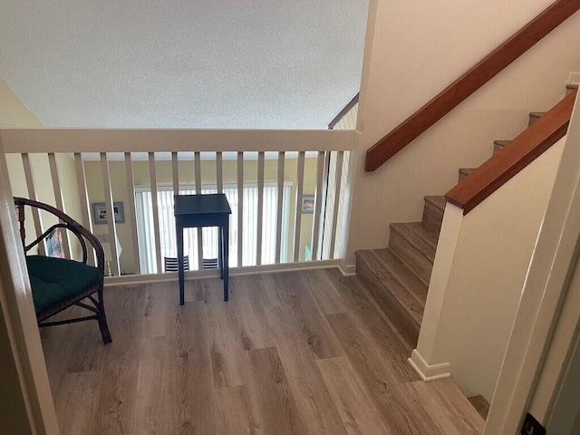 interior space featuring stairs, a textured ceiling, and wood finished floors